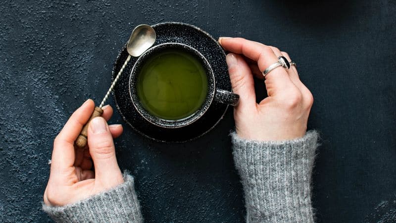 Woman's arms holding tasty green tea