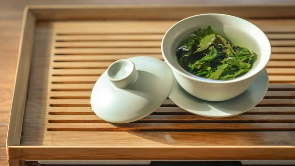 Green tea leaves steeping in a cup